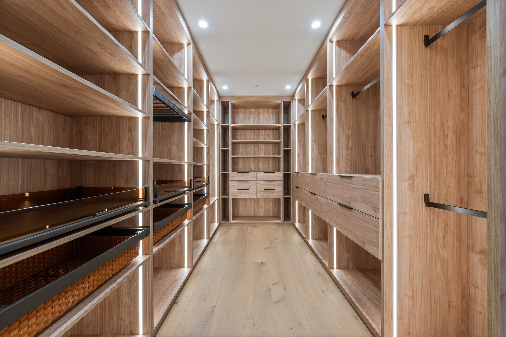 White oak walk-in closet with backlit integrated shelving